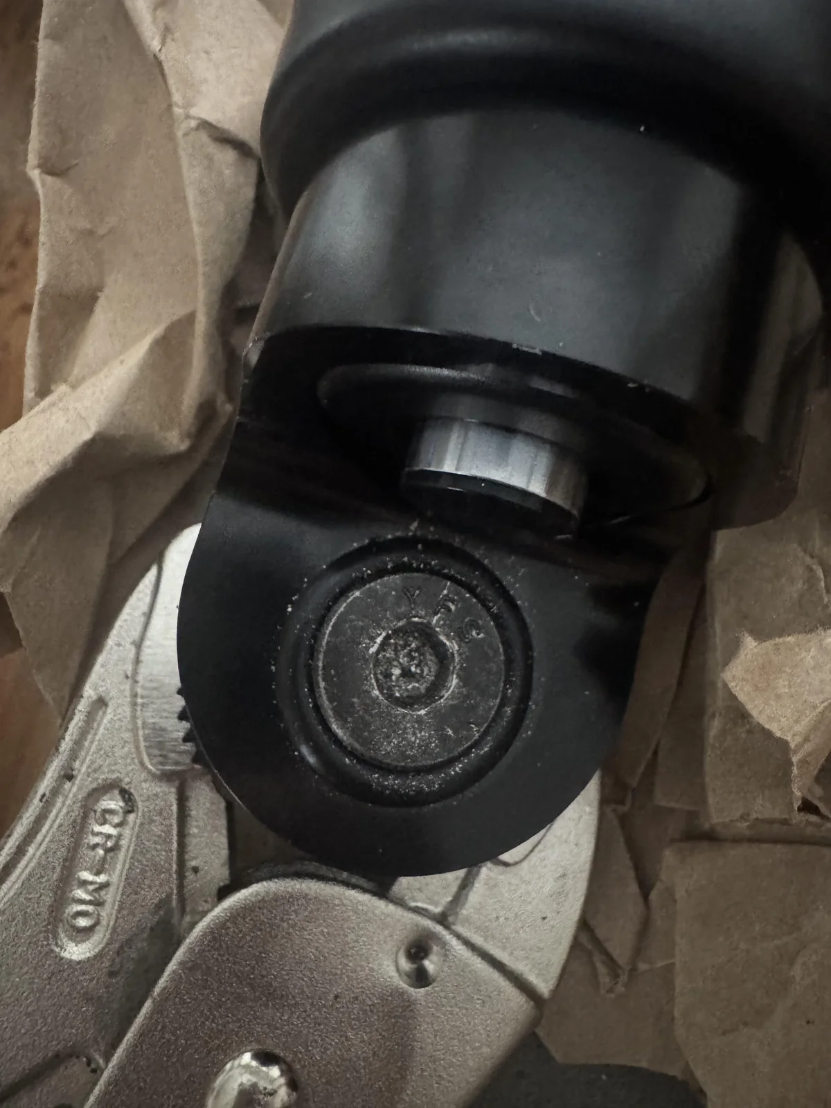 Damaged socket-head fastener in the black clamp, held with locking pliers on packing paper.